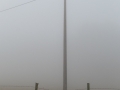 Fence and pylon in the fog